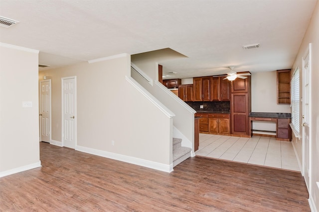 interior space featuring ceiling fan, built in desk, and light wood-type flooring