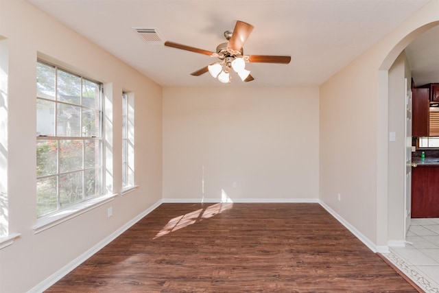 empty room with dark hardwood / wood-style flooring and ceiling fan