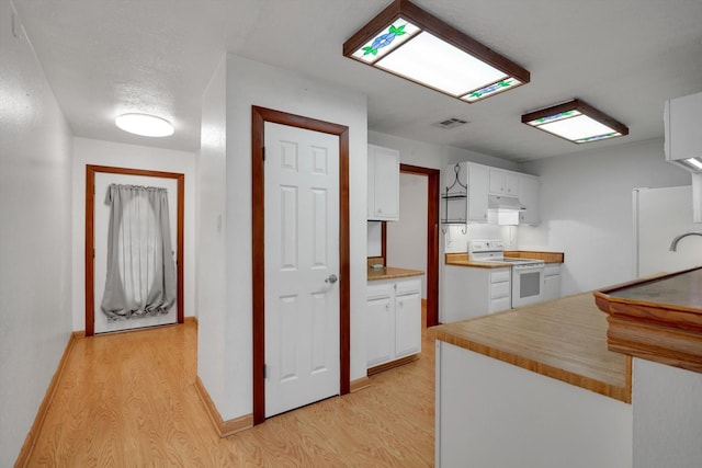 kitchen featuring electric stove, sink, white cabinetry, and light hardwood / wood-style flooring