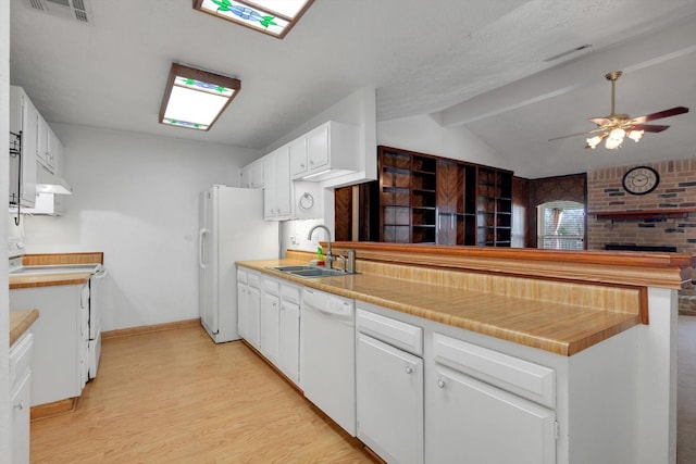 kitchen with lofted ceiling with beams, sink, light wood-type flooring, white cabinets, and white appliances