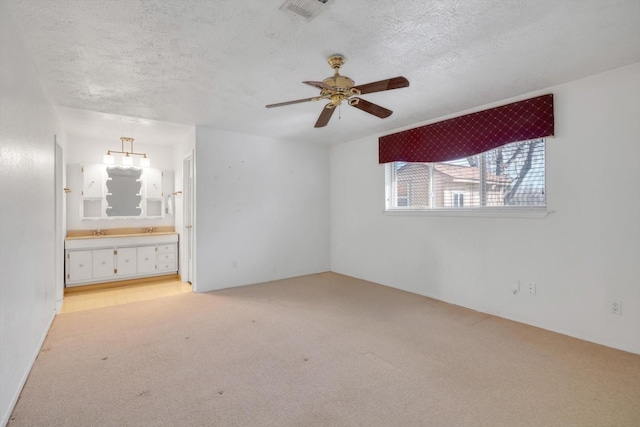 unfurnished bedroom featuring connected bathroom, light colored carpet, and a textured ceiling