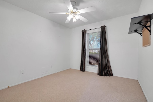 carpeted spare room featuring ceiling fan