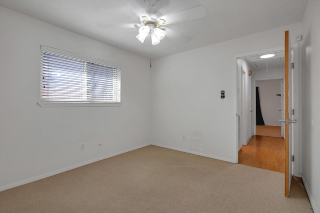 carpeted spare room featuring ceiling fan