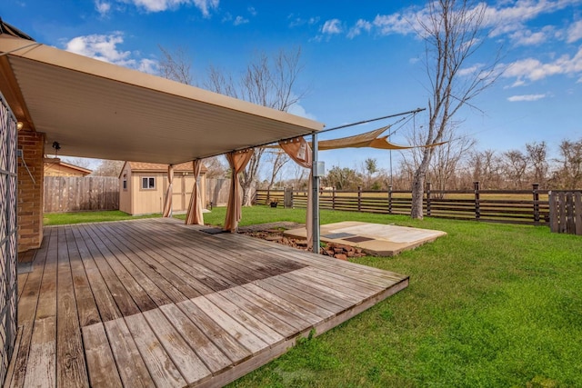 wooden terrace with a storage shed and a yard