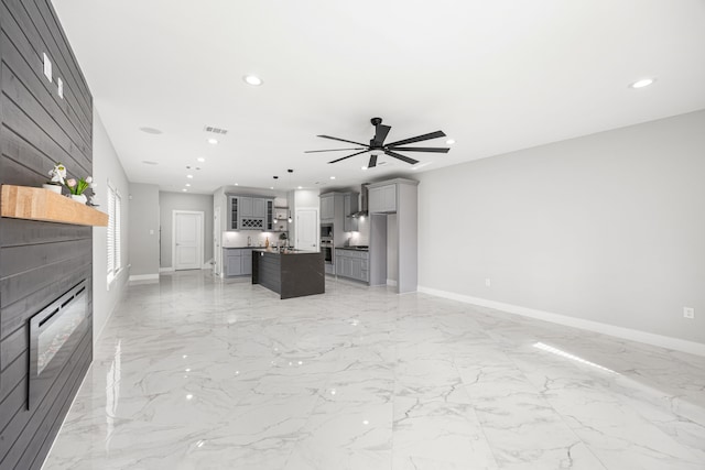 unfurnished living room with ceiling fan and sink