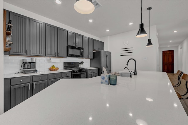 kitchen with sink, tasteful backsplash, gray cabinets, pendant lighting, and black appliances