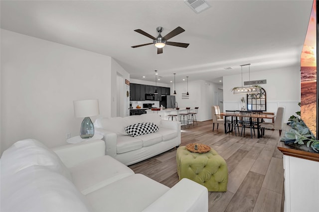 living room with ceiling fan and light wood-type flooring