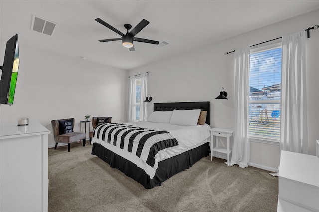 carpeted bedroom featuring ceiling fan and multiple windows