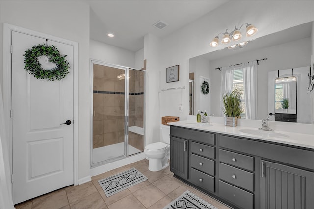 bathroom with tile patterned floors, toilet, a shower with door, and vanity