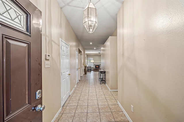 hall featuring an inviting chandelier and light tile patterned floors