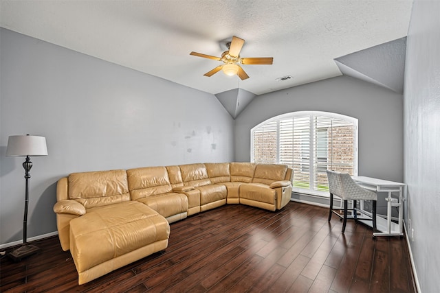 living room with a textured ceiling, dark wood-type flooring, ceiling fan, and vaulted ceiling