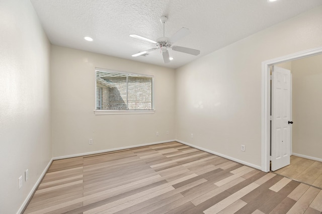 spare room featuring ceiling fan, light hardwood / wood-style floors, and a textured ceiling