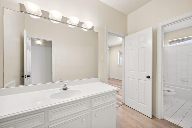 full bathroom featuring vanity, wood-type flooring, tub / shower combination, and toilet