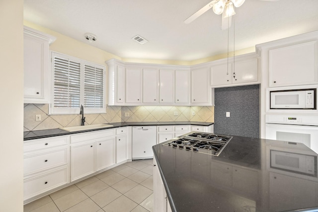 kitchen with white appliances, light tile patterned floors, sink, and white cabinets