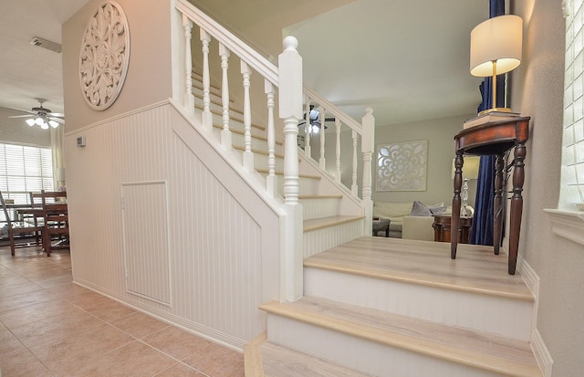 stairway featuring tile patterned flooring and ceiling fan