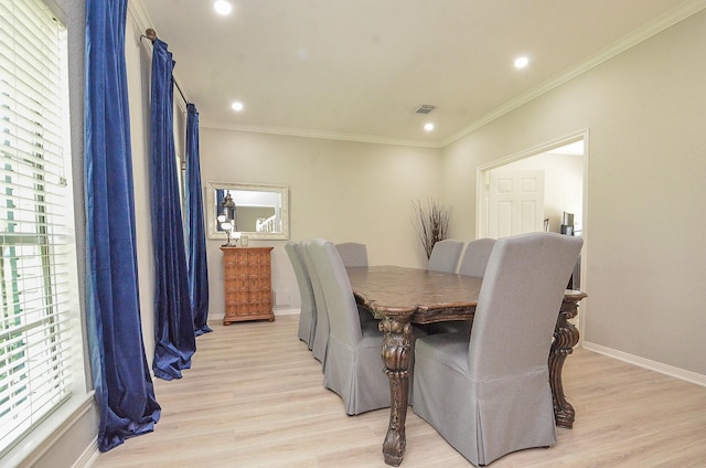 dining area with ornamental molding and light hardwood / wood-style floors