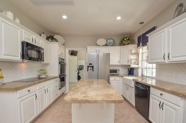 kitchen with pendant lighting, white cabinets, sink, and black appliances