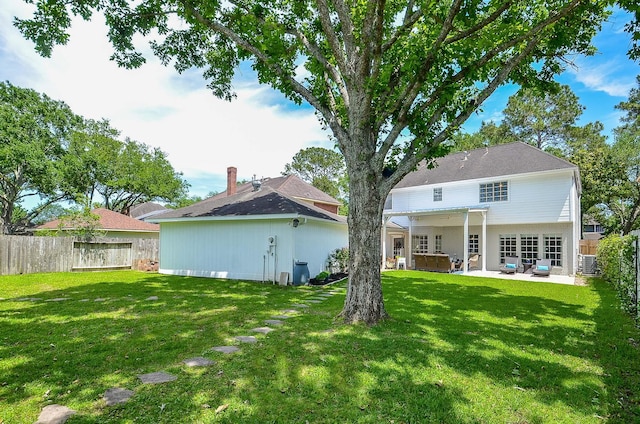 back of property featuring a pergola, a patio area, a hot tub, and a lawn