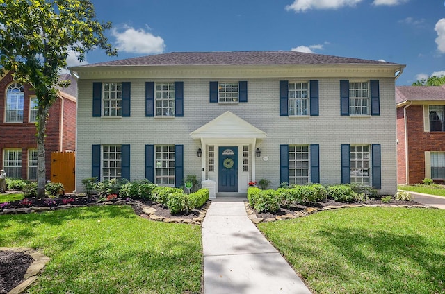 view of front of property featuring a front lawn and brick siding