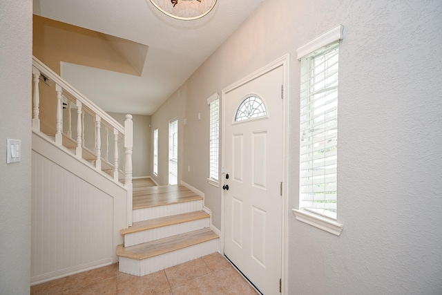 tiled entryway featuring stairs