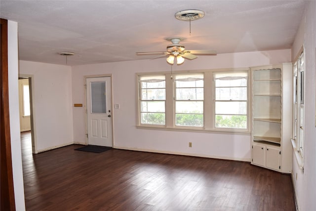 unfurnished living room featuring dark hardwood / wood-style floors and ceiling fan