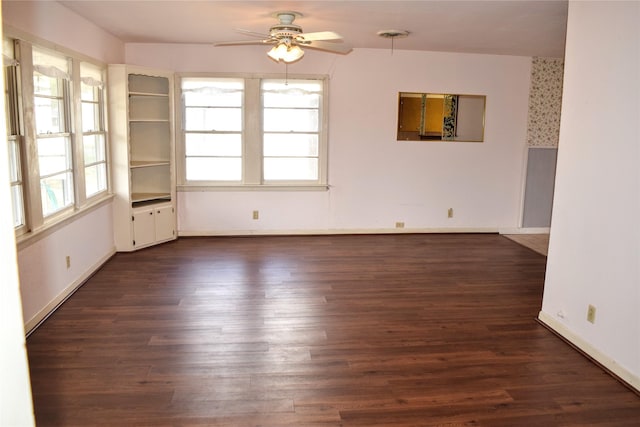spare room featuring dark wood-type flooring and ceiling fan