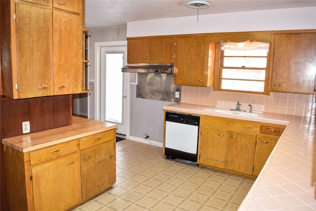 kitchen with sink, backsplash, tile counters, and dishwasher