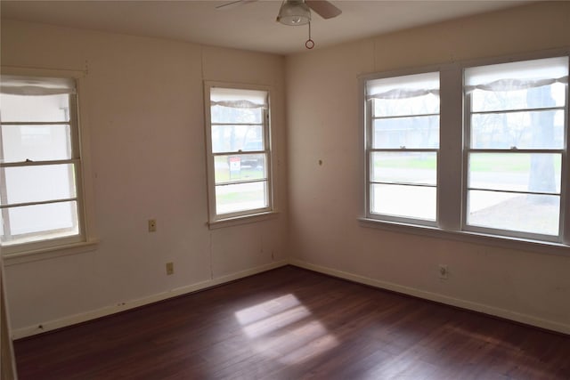 spare room featuring dark wood-type flooring and ceiling fan