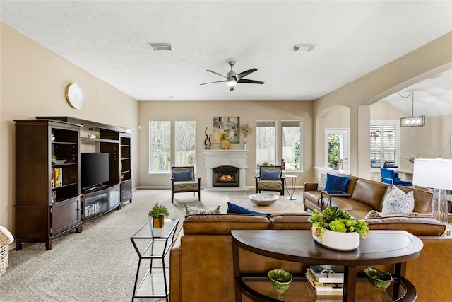 living room with light colored carpet and ceiling fan with notable chandelier