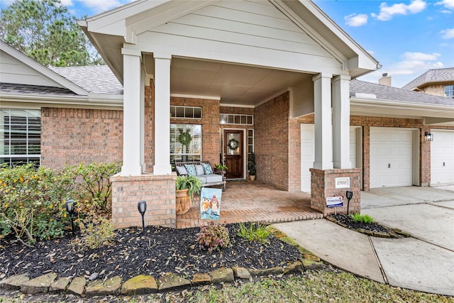 view of exterior entry with a garage and covered porch