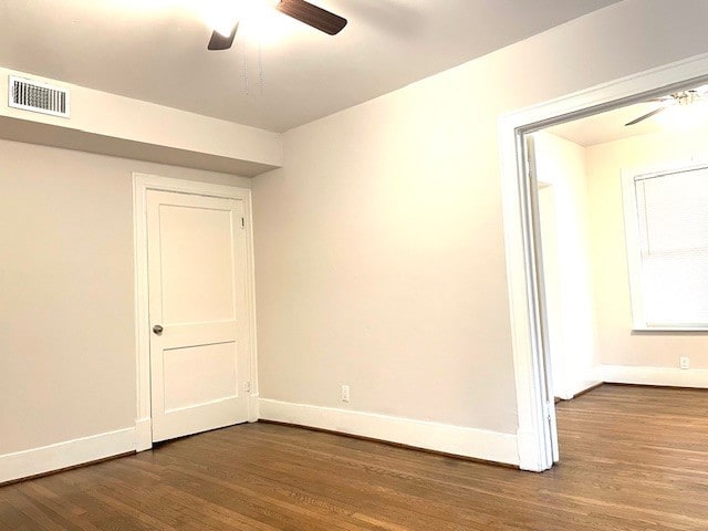 spare room with dark wood-type flooring and ceiling fan