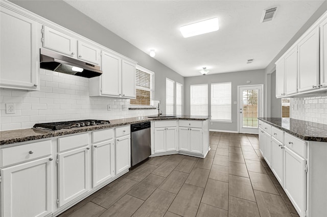 kitchen featuring white cabinetry, appliances with stainless steel finishes, sink, and dark stone counters