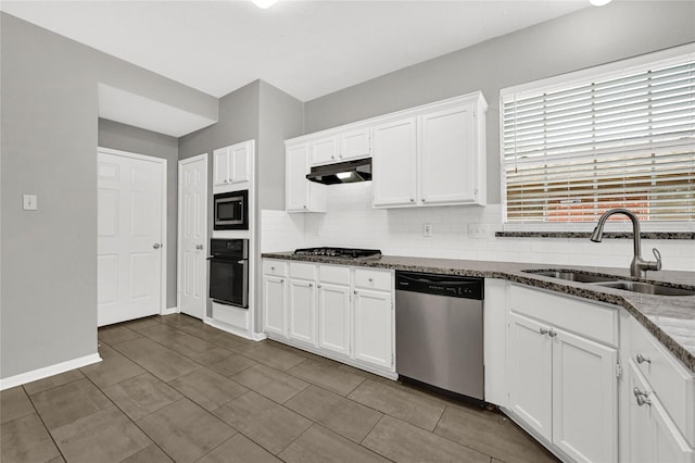 kitchen featuring white cabinetry, sink, backsplash, dark stone counters, and stainless steel appliances