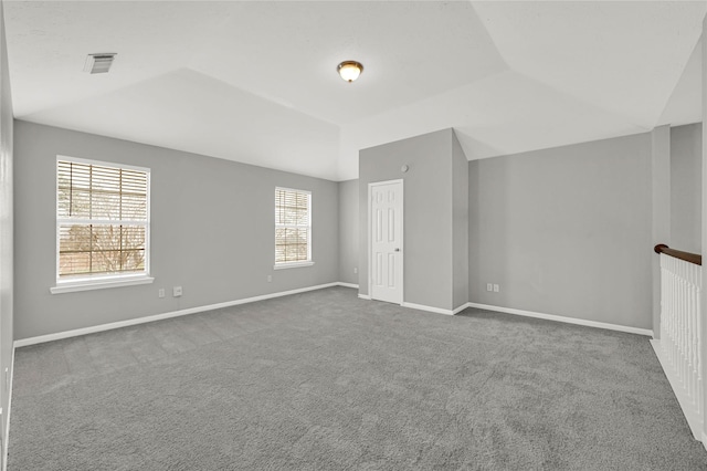 carpeted spare room featuring lofted ceiling