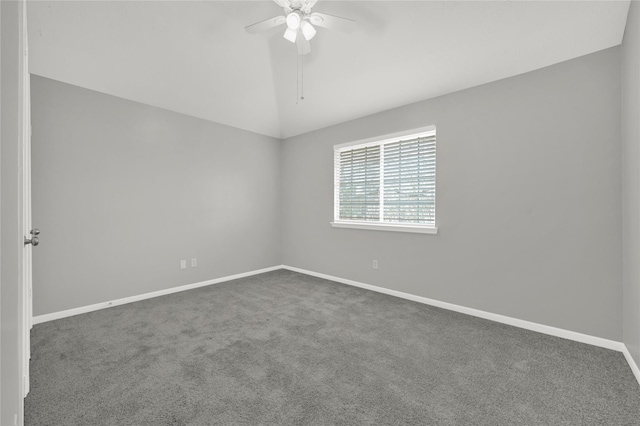 spare room with vaulted ceiling, ceiling fan, and dark carpet