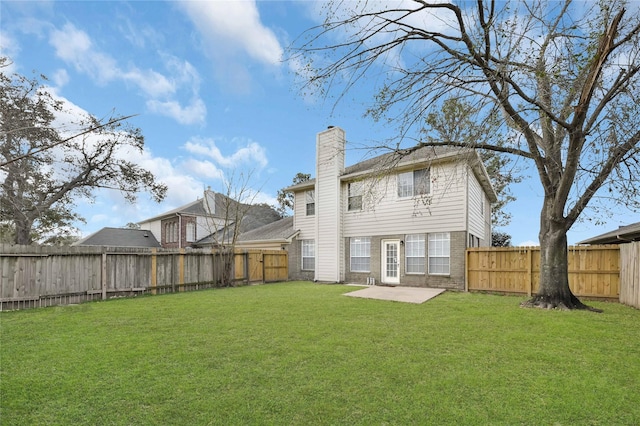 rear view of property featuring a yard and a patio area