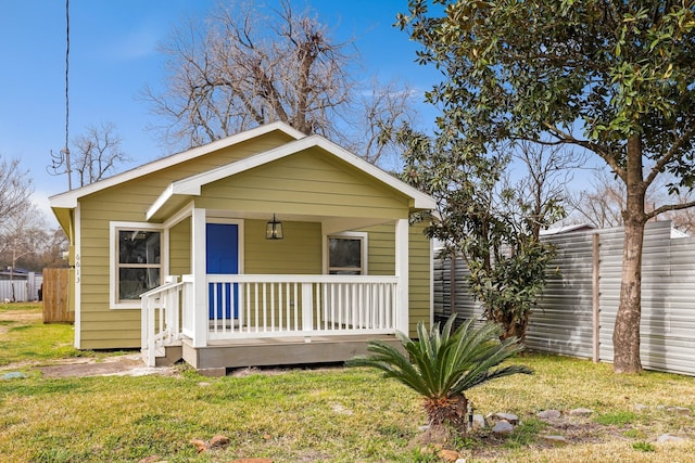 bungalow with covered porch and a front yard