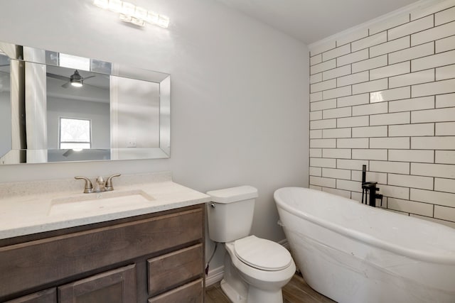 bathroom with vanity, a tub, and toilet