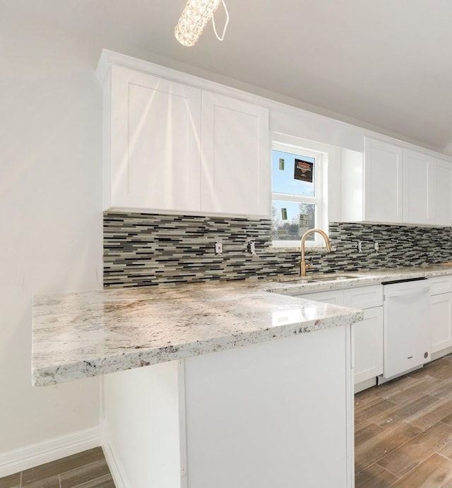 kitchen with sink, dishwasher, white cabinetry, tasteful backsplash, and light stone countertops