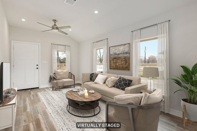 living room with light hardwood / wood-style flooring, ceiling fan, and vaulted ceiling