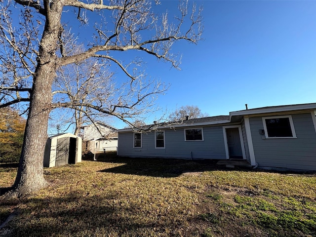 back of property with a shed and a yard