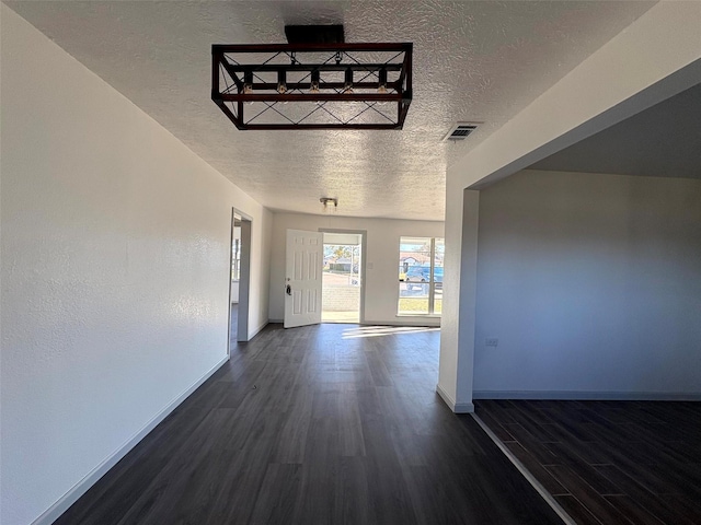 hall featuring a textured ceiling and dark hardwood / wood-style flooring