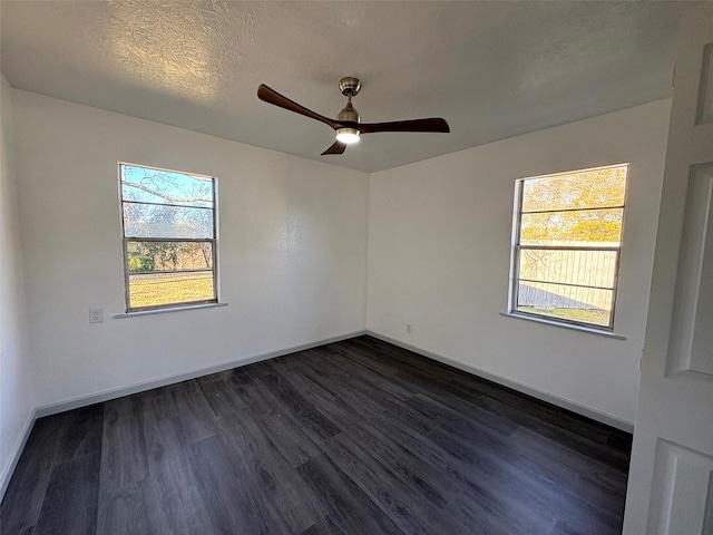 empty room with ceiling fan, dark wood-type flooring, and a textured ceiling