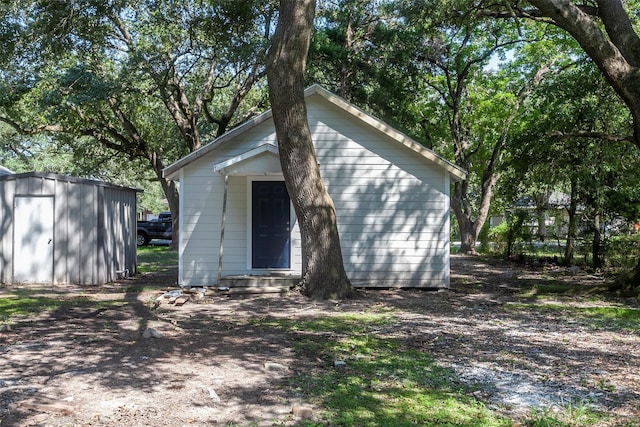 back of property featuring a storage shed