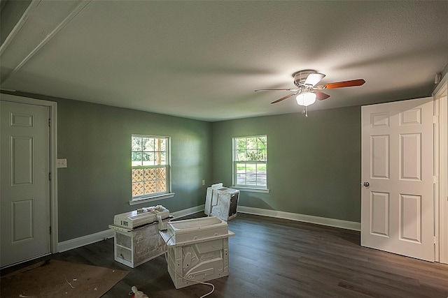 interior space featuring ceiling fan, dark wood-type flooring, and a textured ceiling