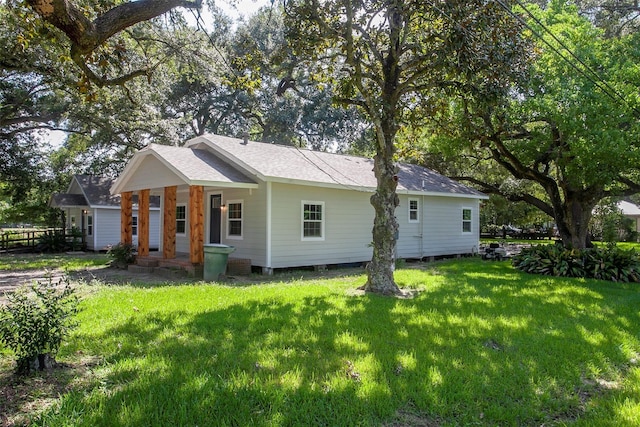 exterior space featuring a shingled roof, a porch, and a lawn