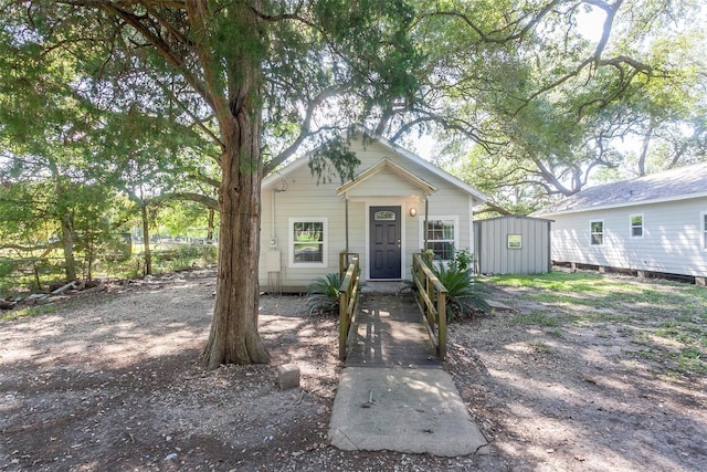 bungalow-style home with a storage unit