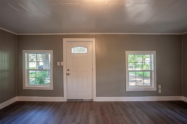 entrance foyer with ornamental molding and dark hardwood / wood-style floors