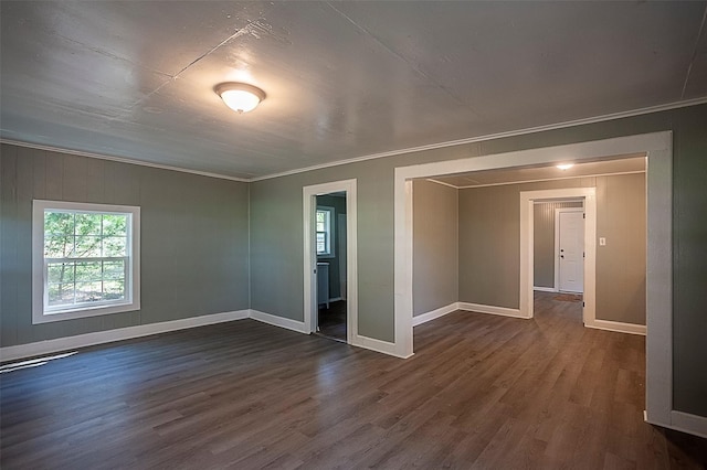 spare room with dark wood-style floors, baseboards, and crown molding