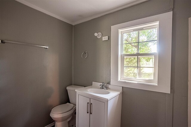 bathroom with vanity, crown molding, and toilet